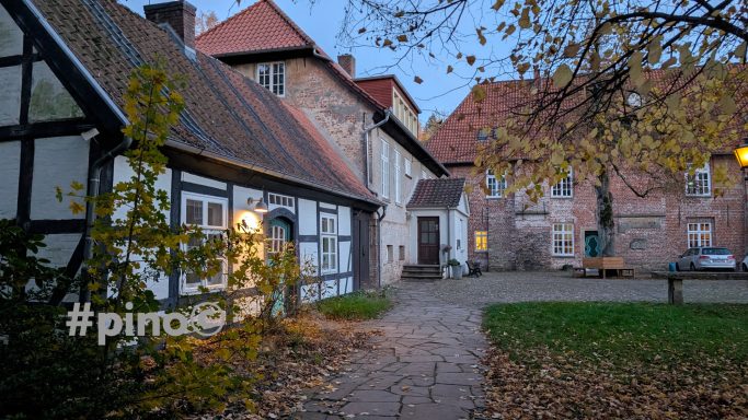 Hinterhof mit historischen Fachwerkhäusern und herbstlichen Blättern.