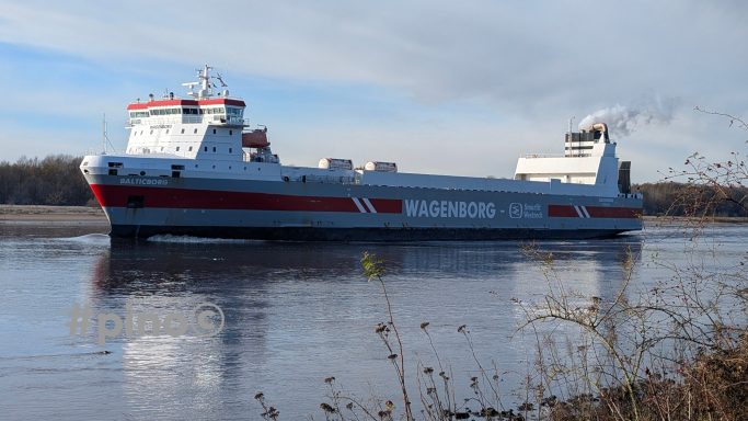 Ein großes Frachtschiff fährt ruhig auf einem Fluss.