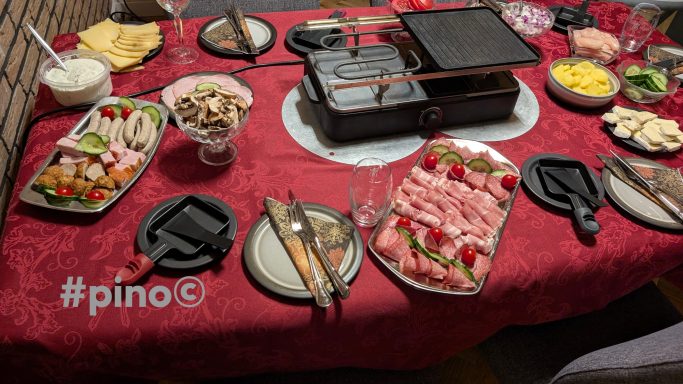 Ein festlich gedeckter Tisch mit verschiedenen Fleischsorten, Gemüse und Dessert.