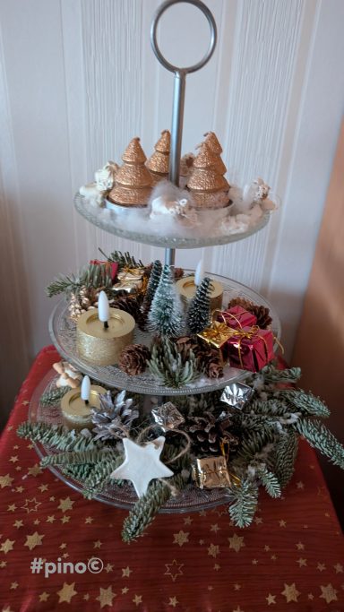 Dreistöckige Etagere mit Weihnachtsgebäck und dekorativen Elementen.