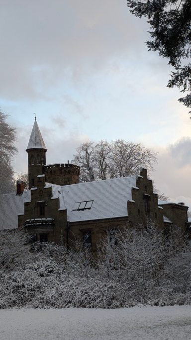 Eisige Winterlandschaft mit einem historischen, schneebedeckten Schloss.