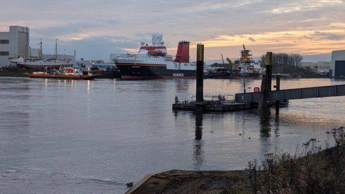 Hafen mit Schiffen und Anlegestellen bei Sonnenuntergang.