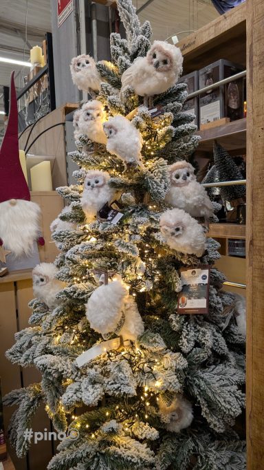 Weihnachtsbaum mit Schneeeulen und warmen Lichtern dekoriert.