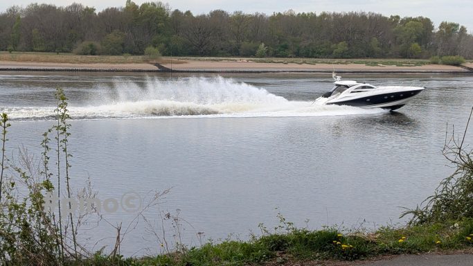 Ein Motorboot schneidet durch das Wasser und hinterlässt eine Spritzspur.